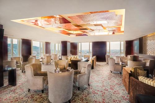 a waiting room with chairs and tables and windows at Best Western Premier Tuushin Hotel in Ulaanbaatar