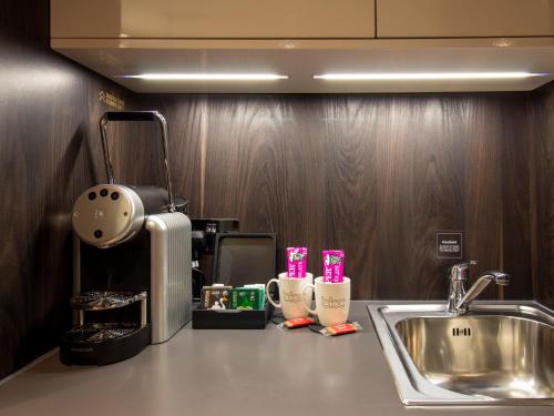 um balcão de cozinha com um lavatório e comodidades para preparar café em Bloc Hotel Birmingham em Birmingham