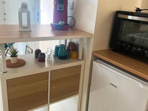 a kitchen with a counter with a microwave and a table at Appartement Cambo-les-Bains, 2 pièces, 2 personnes - FR-1-495-128 in Cambo-les-Bains