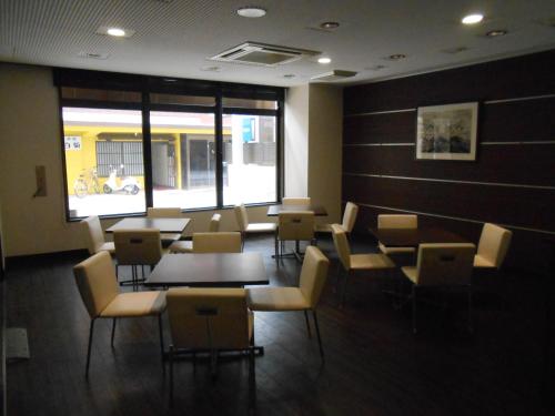 a waiting room with tables and chairs and a window at Business Hotel Sunpu in Shizuoka