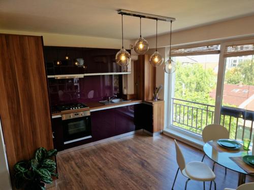 a kitchen with purple cabinets and a table and chairs at Self Check-IN Free Parking Near Metro Stations and BUS WestSide Studio S6 in Bucharest