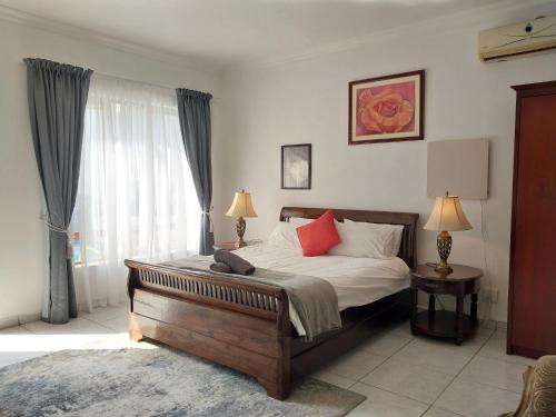 a bedroom with a bed and a large window at The Freshwater Pearl in Pretoria