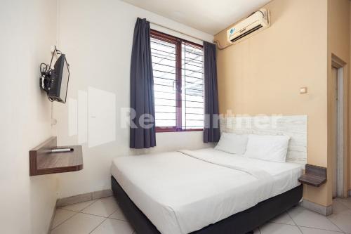 Tempat tidur dalam kamar di One 2 Residence near Slipi Jaya Mall Mitra RedDoorz