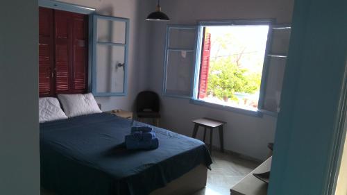 um quarto com uma cama azul e uma janela em Villa Antoinette em Metímna