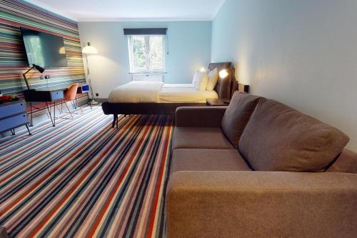 a living room with a couch and a bed at Village Hotel Cardiff in Cardiff