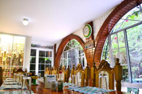 a dining room with a table and some windows at Hotel Oasis in San Salvador