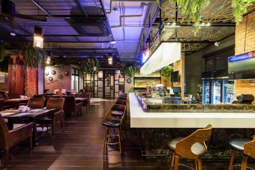 芭達雅中心的住宿－T Pattaya Hotel by PCL，餐厅设有酒吧和桌椅