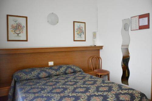 a bedroom with a bed with a blue comforter at Hotel Primo in Riva del Garda