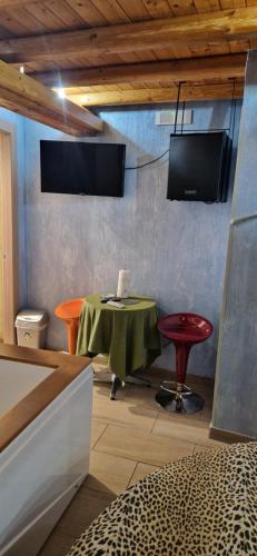 a room with a table and a chair and a tv at B&B Mongibello in Viagrande