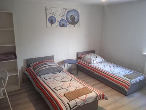 ein Schlafzimmer mit 2 Betten und einem Tisch darin in der Unterkunft Apartamenty Przy Rynku in Żnin