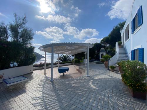 a pavilion with a table and a bench on a patio at Magi - Villa Amare in Ponza