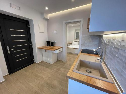 ネア・フォケアにあるAndrea's luxury apartments in Nea Fokaiaのキッチン(シンク付)、黒いドア
