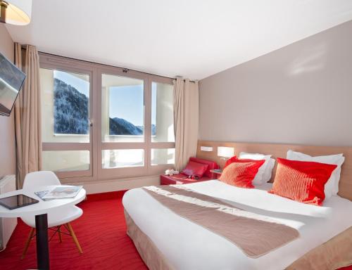 a hotel room with a large bed and a large window at SOWELL HOTELS Le Pas du Loup in Isola 2000