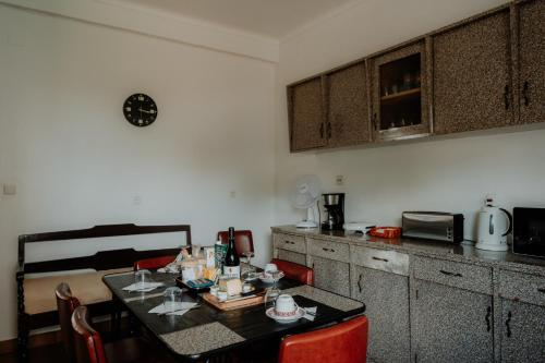 a kitchen with a table with red chairs and a counter at Casa Sousa Ribeiro in Praia da Vitória