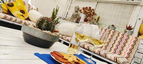 a table with a glass of wine and a plate of food at Villa Yandre Garden House - Ayamonte in Ayamonte