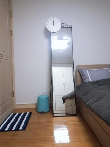 a bedroom with a mirror and a bed and a clock at Changdong Property in Seoul