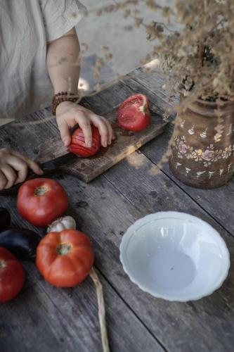 a person cutting tomatoes on a wooden table at The house in the village in Tirana