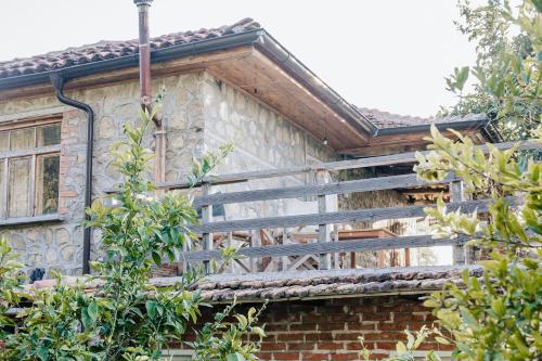 a house with wooden stairs on the side of it at The house in the village in Tirana