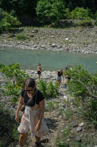 a woman walking down a path next to a river at The house in the village in Tirana
