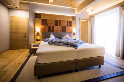 a bedroom with a large bed in a room at Flora - Das kleine Gartenhotel in Ellmau