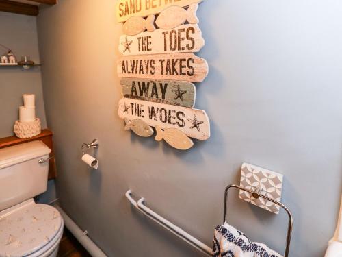 a bathroom with a towel rack with seashells on the wall at Riverdance Cottage in Lyme Regis