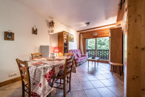 une cuisine et une salle à manger avec une table et des chaises dans l'établissement Appart Cosy 3 étoiles, à Arâches-la-Frasse