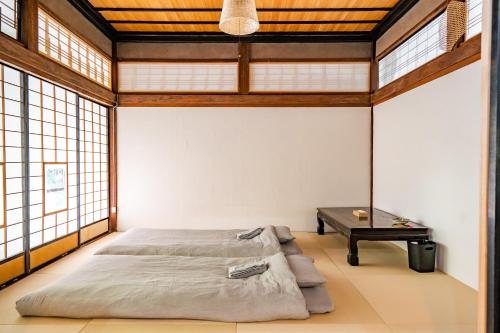 A bed or beds in a room at 恐竜博物館より車で15分 -1組様限定の築140年の古民家農家民宿 "晴れのちもっと晴れ" 里山集落で超田舎滞在- 昔懐かしい五右衛門風呂とにわとり卵の収穫体験付き