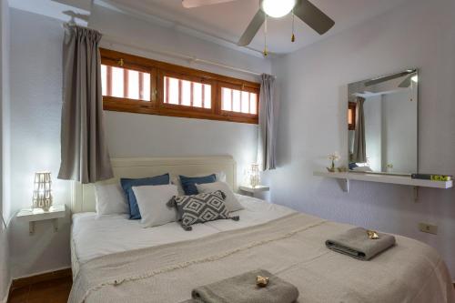 Schlafzimmer mit einem großen weißen Bett und einem Fenster in der Unterkunft Garden City Private Apartment Costa Adeje in Playa Fañabe