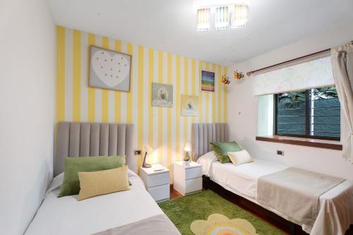 um quarto com 2 camas e uma janela em Villa Palmeras, un remanso de paz em Candelaria