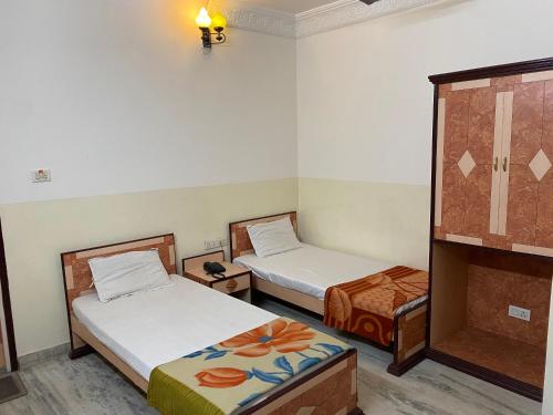 Cette chambre comprend 2 lits et un miroir. dans l'établissement Hotel Mayur, à Purulia