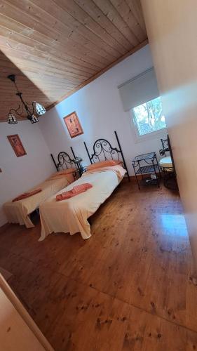 ラ・オリーバにあるCasa Helenaのベッド2台と木製の床のある寝室