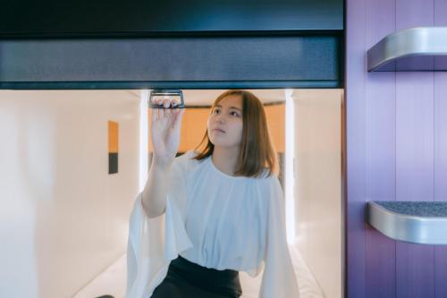 a woman taking a picture of herself in a mirror at NADESHIKO HOTEL TOKYO Shibuya by unito Female-only in Tokyo