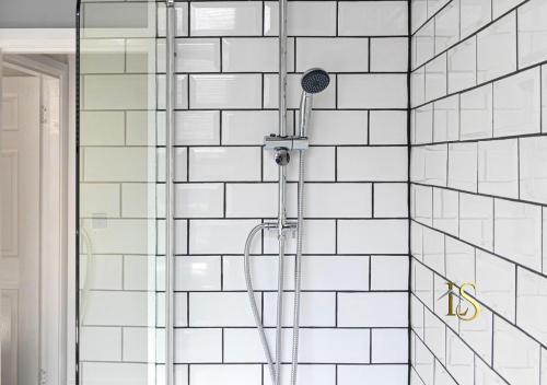 La salle de bains est pourvue d'une douche et de murs carrelés blancs. dans l'établissement Luke Stays - Belle Grove West, à Town Moor