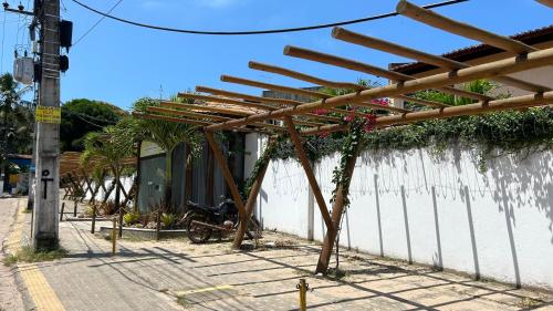 a wooden pergola on the side of a building at Loft Solar Água in Pipa