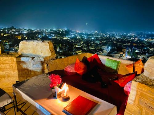 a view of a city at night with a bed and candles at Hotel Lotus Haveli in Jaisalmer