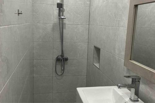 La salle de bains est pourvue d'une douche et d'un lavabo. dans l'établissement Maison de ville à Flic-en-Flac, à Flic-en-Flac