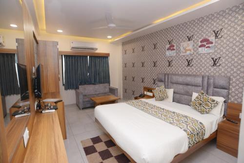 a hotel room with a bed and a chair at HOTEL LEE GOLD in Anand