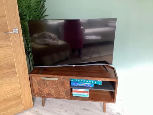 een tv-scherm met een houten tafel met een lade bij Red Skies Seaview Portstewart Beach Golfcourse Seafront View in Portstewart