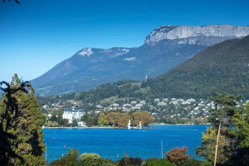 a large body of water with a town and mountains at Le Pélican in Annecy