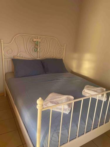 a white bed with blue sheets and blue pillows at Melianto House in Mithymna