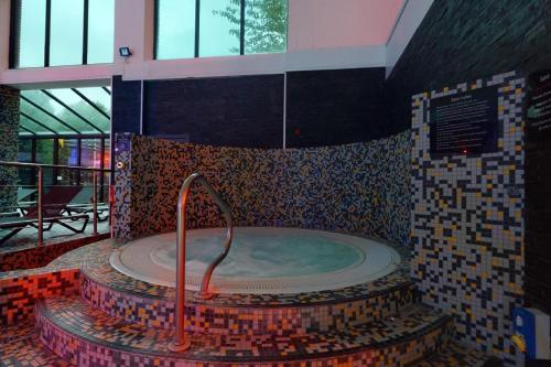 a jacuzzi tub in a building with mosaic tiles at Village Hotel Cardiff in Cardiff