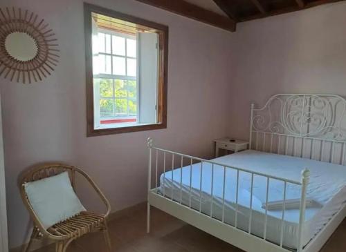 ein Schlafzimmer mit einem Bett, einem Stuhl und einem Fenster in der Unterkunft O Abrigo in Laje