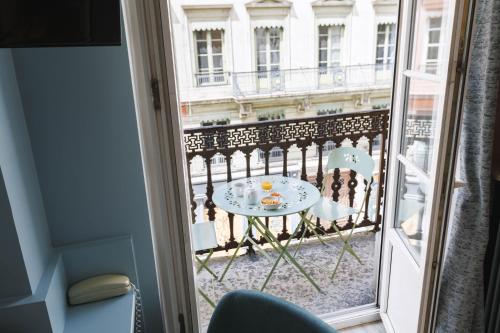 a view of a table and chairs from a window at Hôtel du Dauphin in Lyon