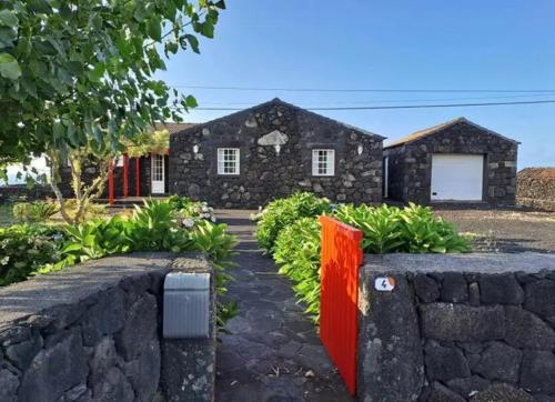 a stone wall in front of a house at O Abrigo in Laje