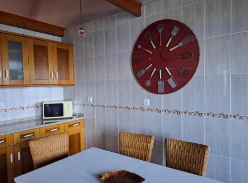 una cocina con un reloj rojo en la pared en O Abrigo, en Laje