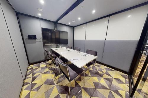 a conference room with a table and chairs at Village Hotel Cardiff in Cardiff