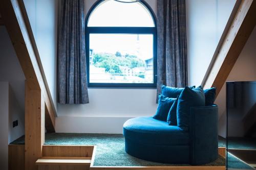 a blue chair in a room with a window at Le Pélican in Annecy