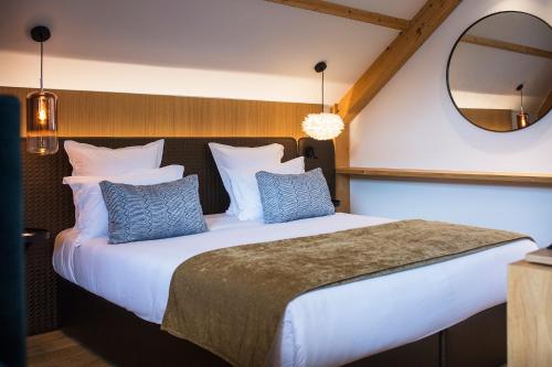 a bedroom with a large white bed with blue pillows at Le Pélican in Annecy