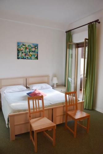 a bedroom with a bed and two chairs at Hotel Imperiale in Fiuggi