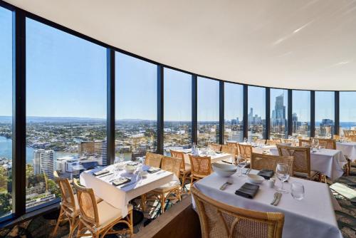 a dining room with tables and chairs and floor to ceiling windows at Crowne Plaza Surfers Paradise, an IHG Hotel in Gold Coast
